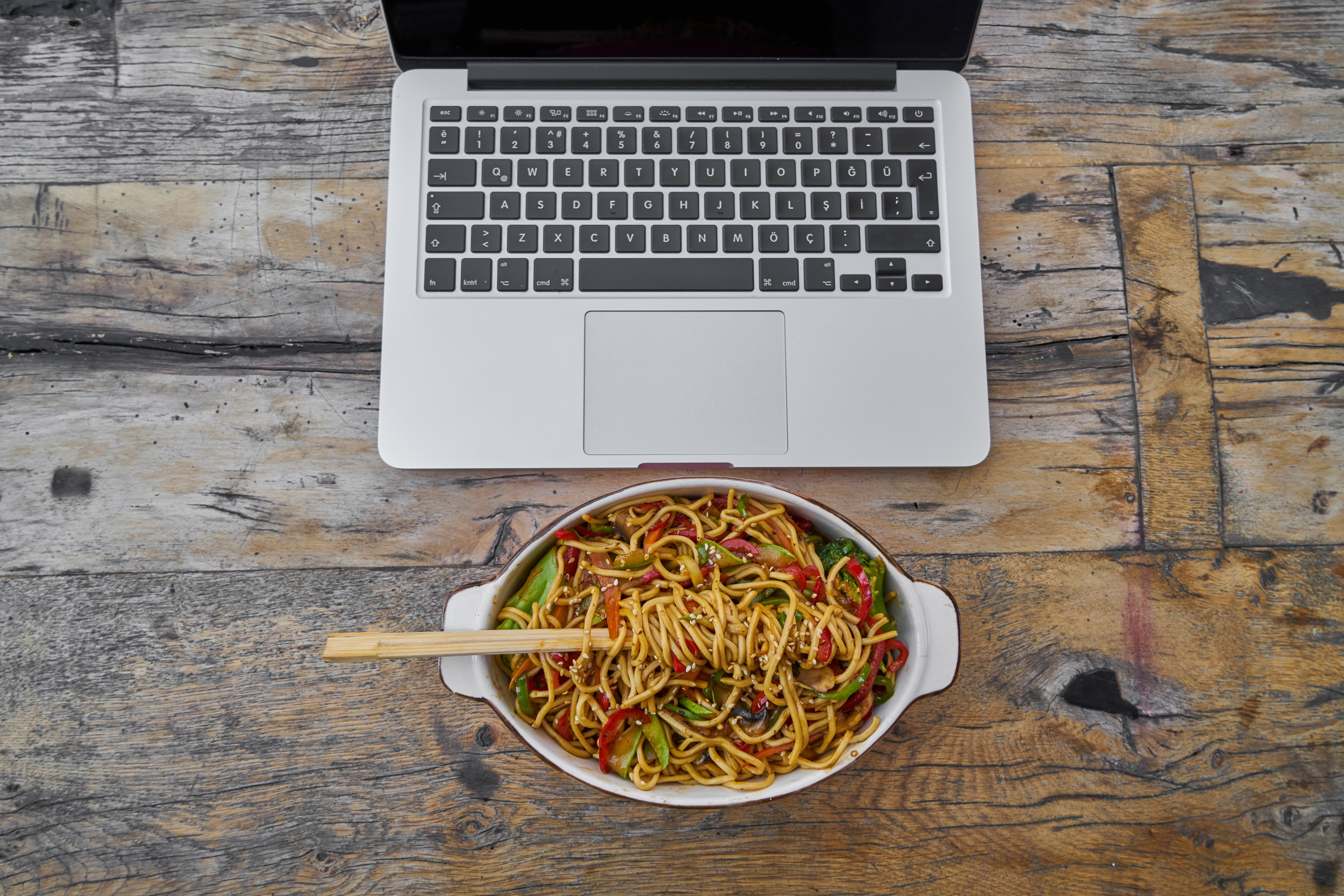 bovenaanzicht op laptop en bord met pasta